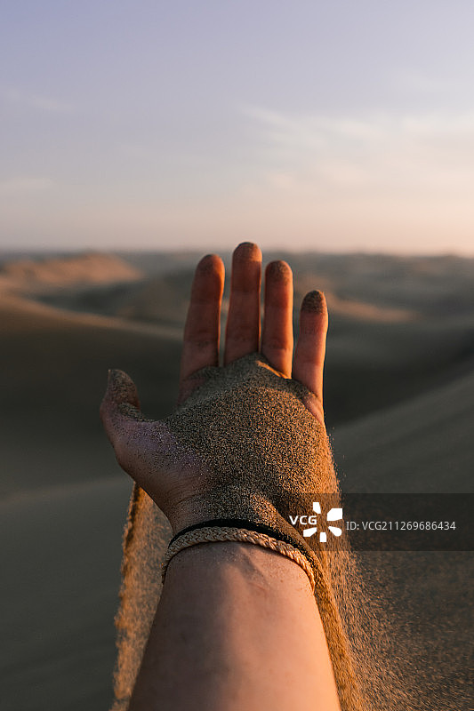 秘鲁伊卡，沙子从女子手指间滑落图片素材