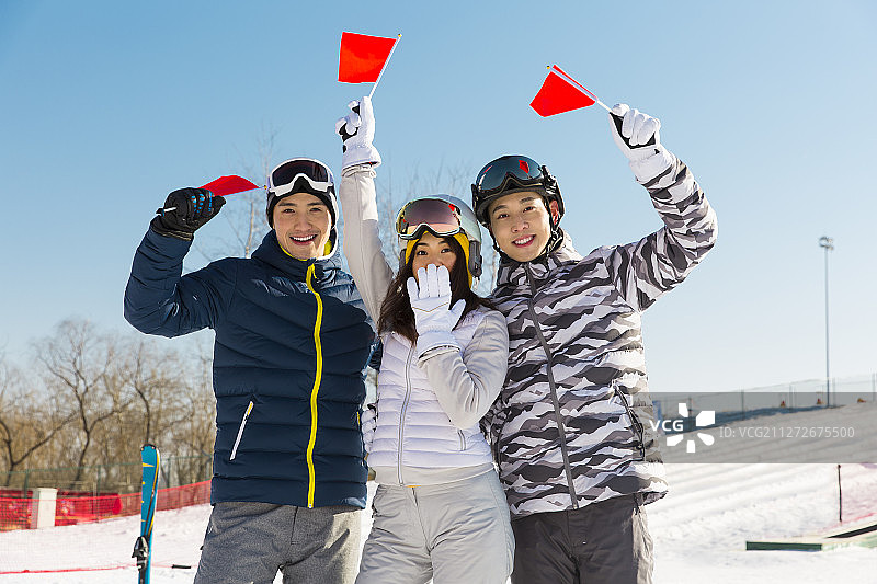 三个年轻男女在户外滑雪场为比赛加油喝彩图片素材