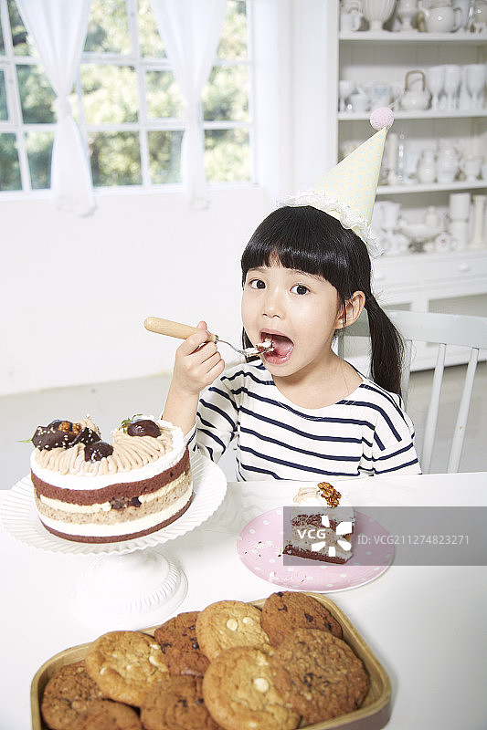 小女孩参加生日聚会吃蛋糕的照片图片素材