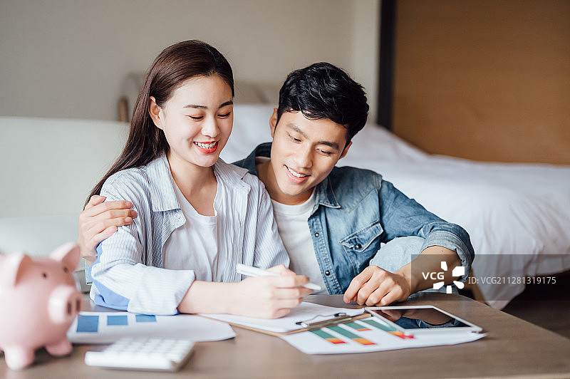 亚洲年轻情侣在家理财图片素材