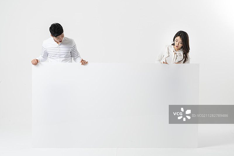 一对夫妇站在巨大的白色空白横幅后面的照片图片素材