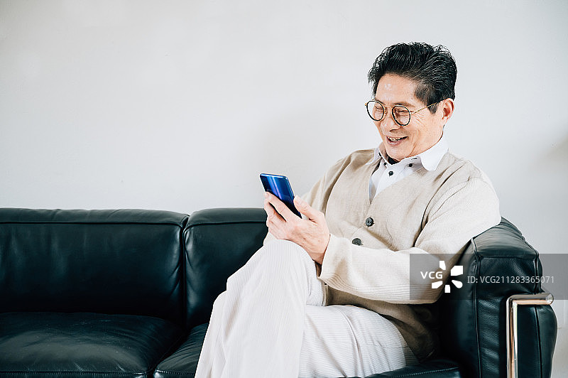 亚洲老年男性使用智能手机图片素材
