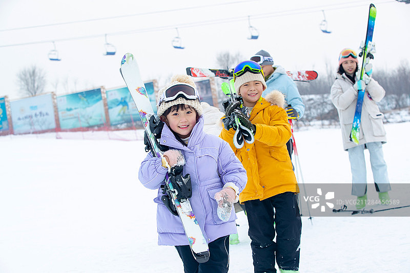 滑雪场内扛着雪具的一家四口图片素材