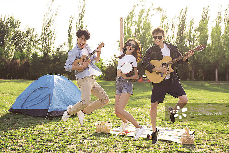 快乐的年轻人在户外聚会演奏音乐图片素材