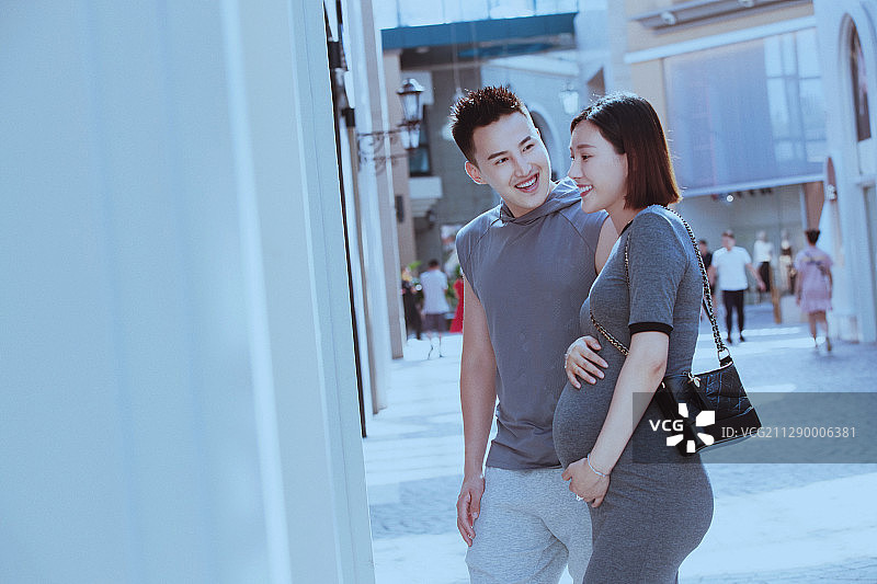 丈夫陪着怀孕的妻子逛街购物图片素材