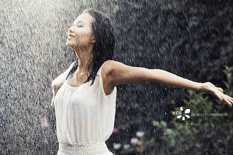 快乐的女人在雨中跳舞图片素材