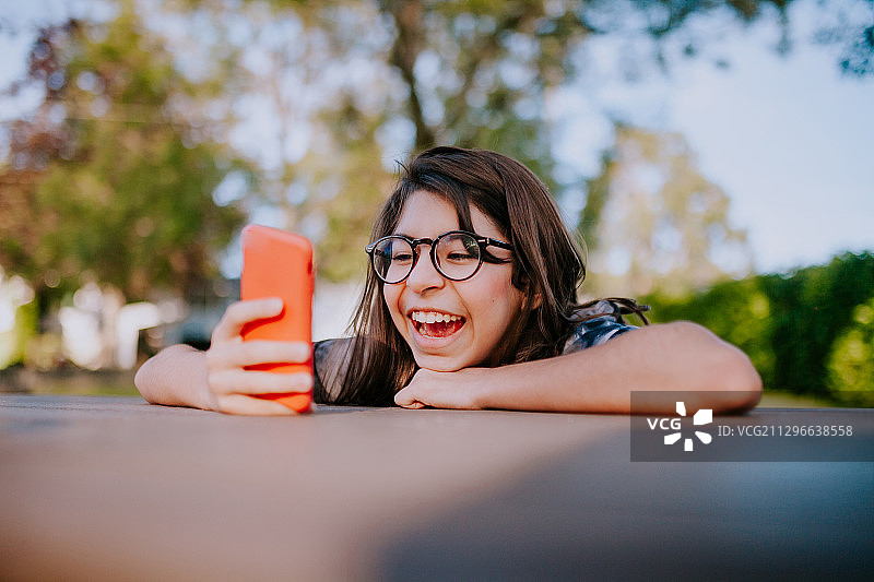 加拿大维多利亚公园，一名女孩正在和朋友玩手机图片素材