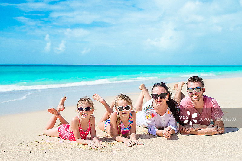 微笑的家庭在海滩放松的肖像图片素材