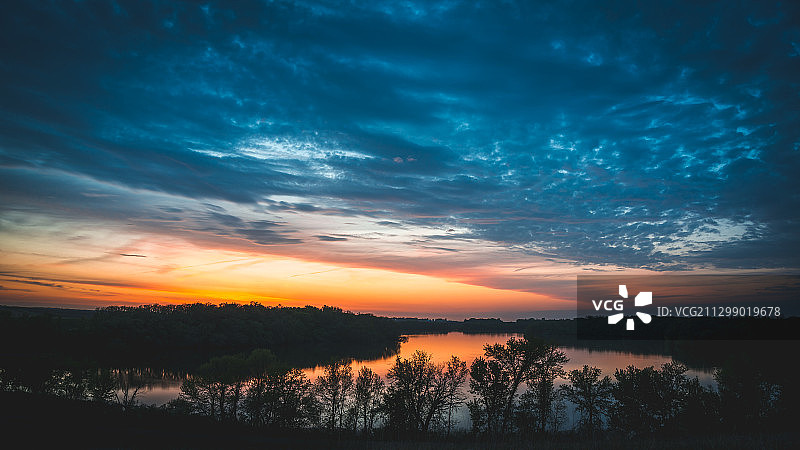 日落时分天空映衬的湖景图片素材
