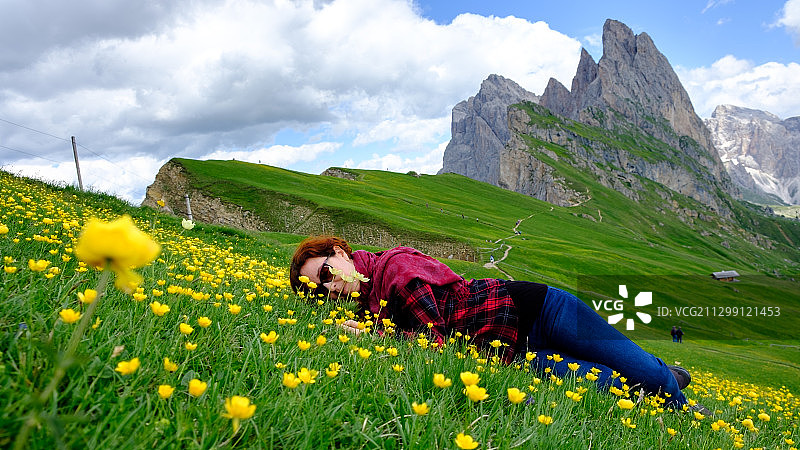 意大利奥尔提塞，一名女子躺在多云的天空下图片素材