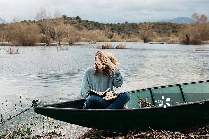 克罗地亚波德戈拉，一名女子在湖上划船看书图片素材