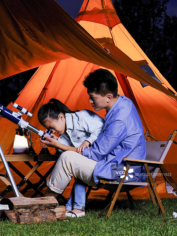 快乐的父女俩在户外使用天文望远镜图片素材
