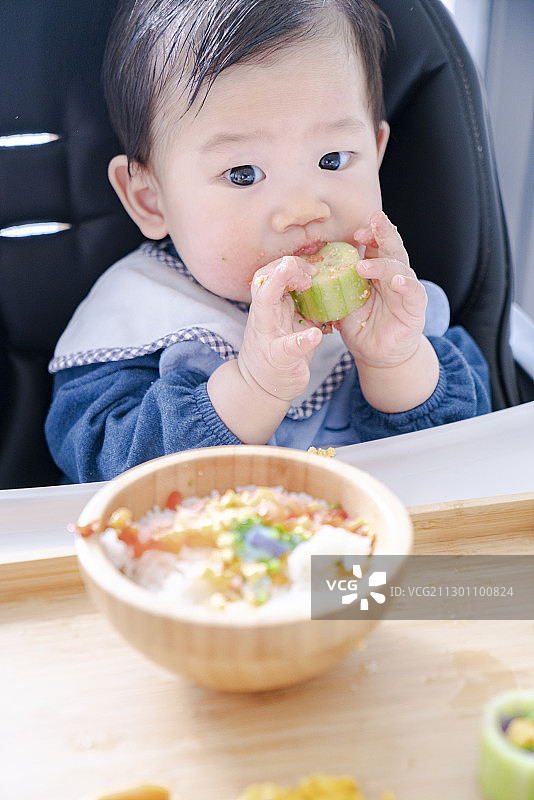 婴儿自己进食时的可爱表情图片素材