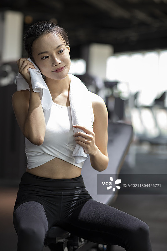年轻女士在健身房健身后休息图片素材