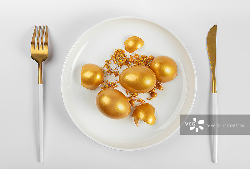 叉子餐具盘子里的金蛋金珠子图片素材