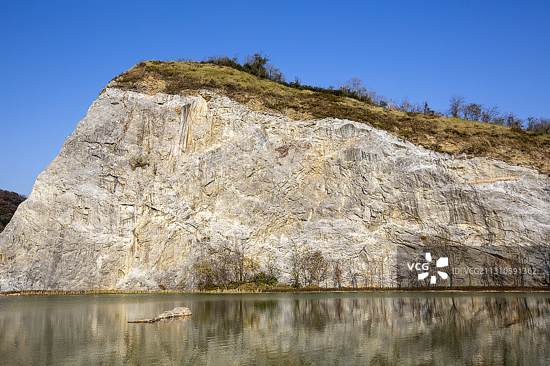 刀削般陡峭的石崖矗立在一池清水之上图片素材