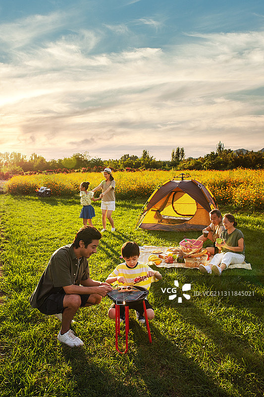 欢乐的一家人在郊外野餐烧烤图片素材