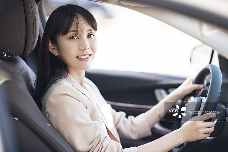 年轻女子驾驶小轿车图片素材