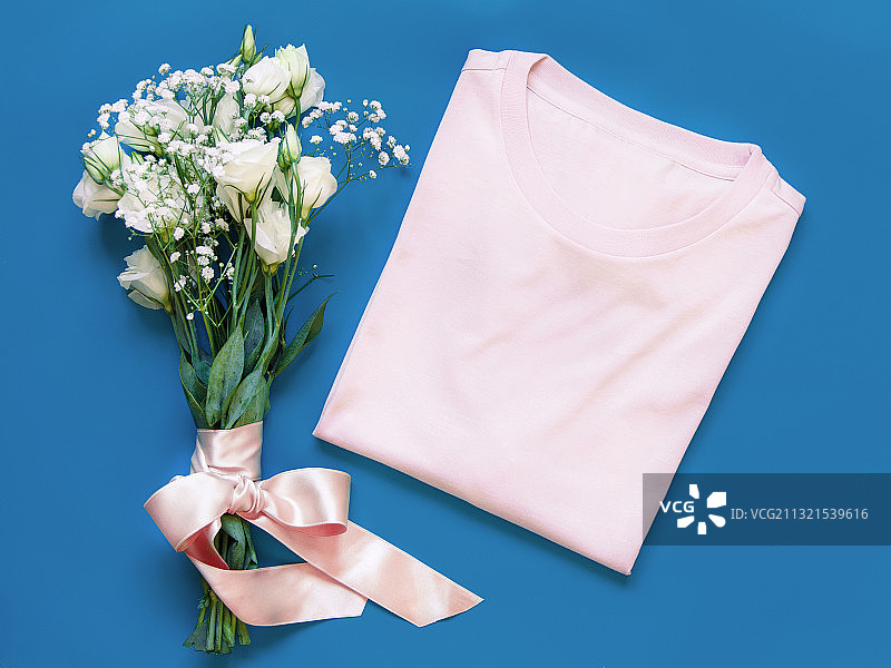 高角度的花和粉红色的衬衫在蓝色的背景图片素材
