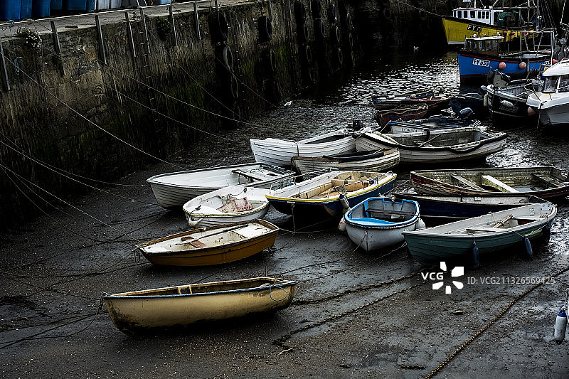 英国，低潮时停泊在港口的渔船的高角度视图。图片素材