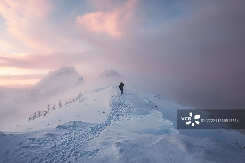 挪威森雅，人在白雪覆盖的山上行走图片素材