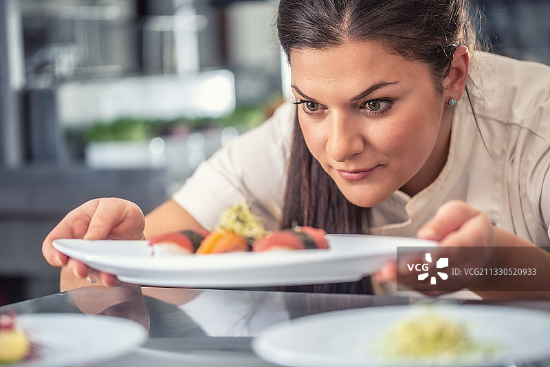 热情的职业女厨师介绍她的寿司美味图片素材