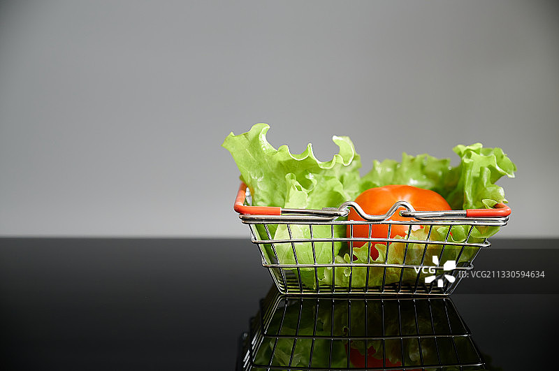 蔬菜在购物车的桌子上的特写，以灰色的背景图片素材