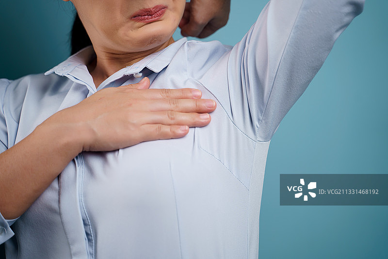 在蓝色背景下，胸部疼痛的女性腹部图片素材