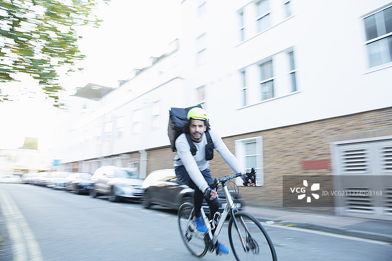 男性自行车信使在城市街道上送食物图片素材