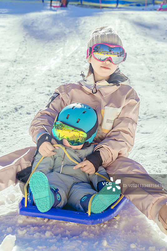 母婴坐着滑雪板去滑雪图片素材
