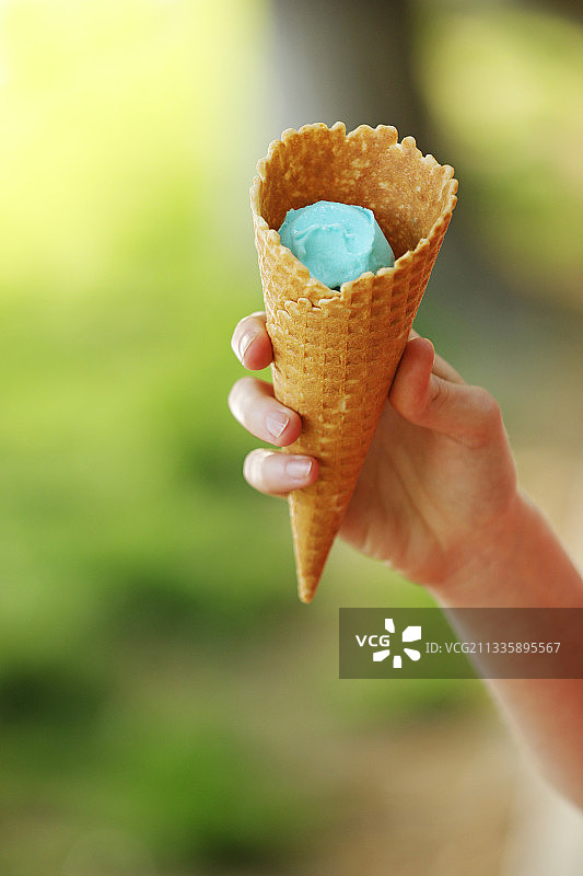 手里拿着蓝色冰淇淋的女士近距离看图片素材