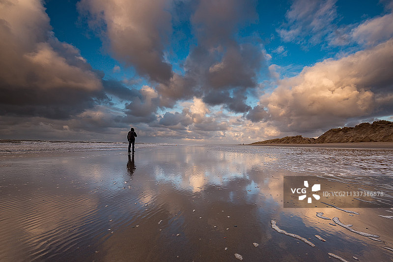 夕阳西下，荷兰泽兰海滩上，一名男子的剪影图片素材
