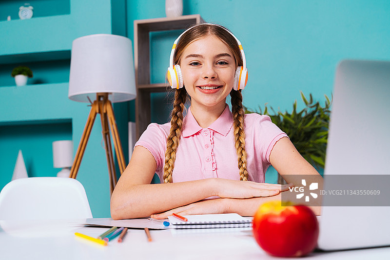 微笑的年轻女孩在办公室使用笔记本电脑的肖像图片素材