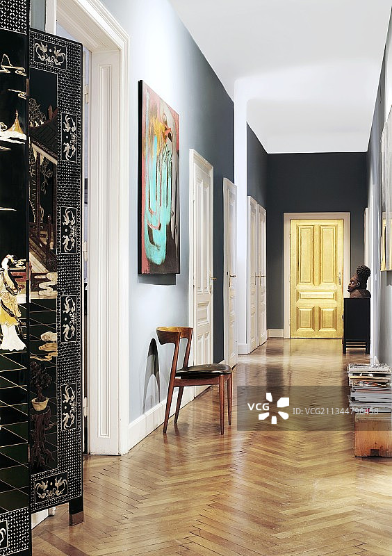 在维也纳时期的公寓里，长长的走廊尽头有一扇金色的、发光的门;中文屏幕在前景的一边图片素材