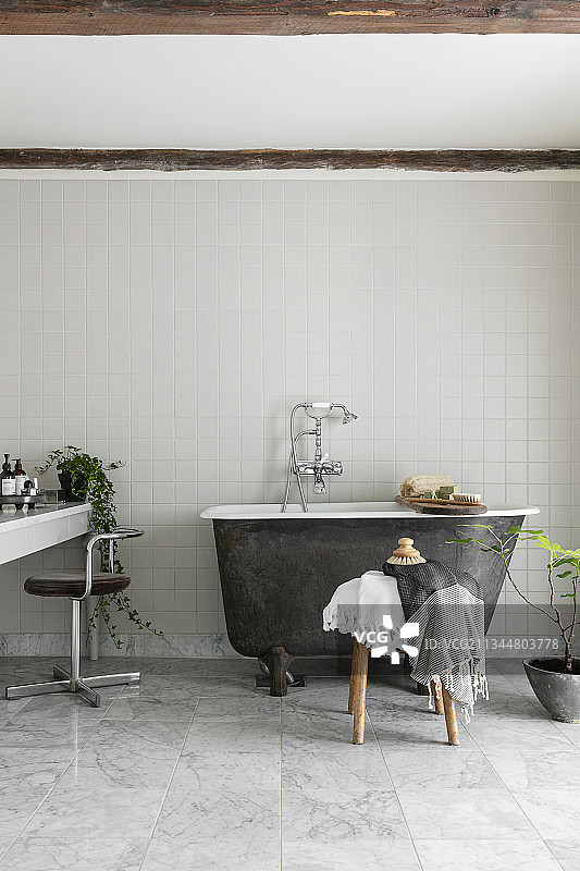 小的，独立的浴缸在简单的浴室灰白色图片素材