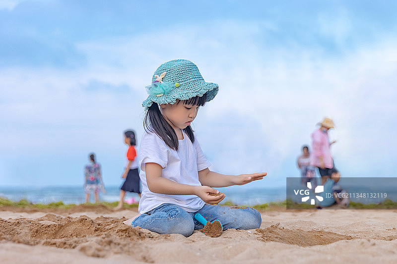 沙滩上玩沙子的小女孩图片素材