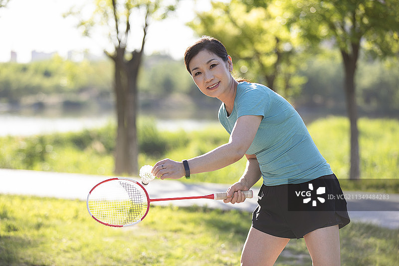 开心的中老年女子在户外打羽毛球图片素材