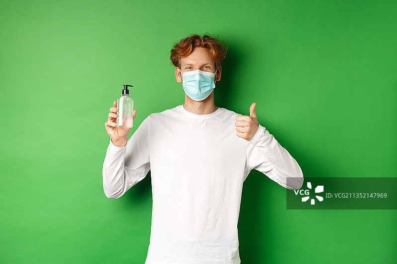 一名男子戴着防护面具，站在绿色背景下图片素材