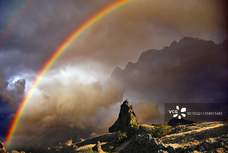 在天空映衬下，彩虹横跨山脉的风景图片素材