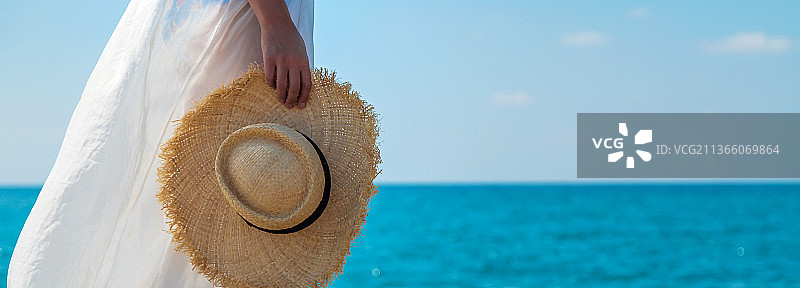戴着帽子的女人在沙滩上选择焦点图片素材