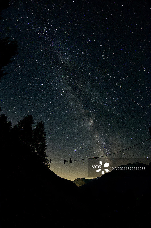 瑞士山上的星星，夜晚在天空的映衬下，低角度看山的剪影图片素材