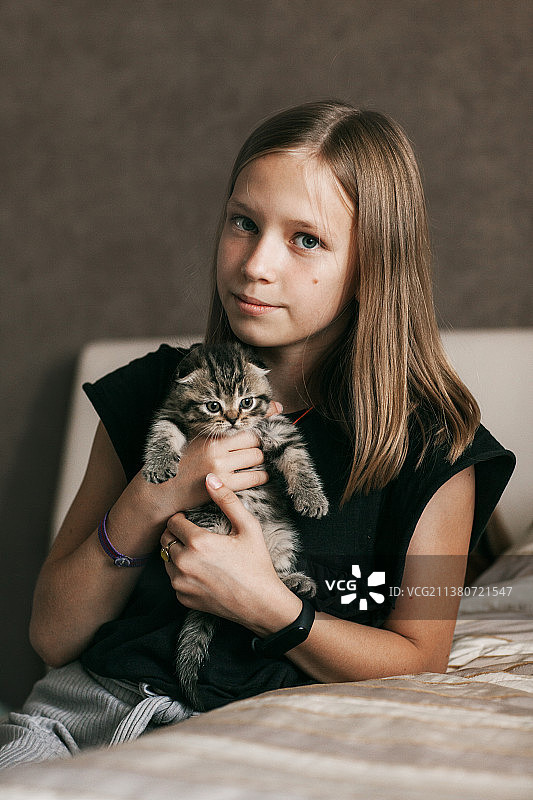 白俄罗斯女孩拥抱并扮演一只英国小猫图片素材