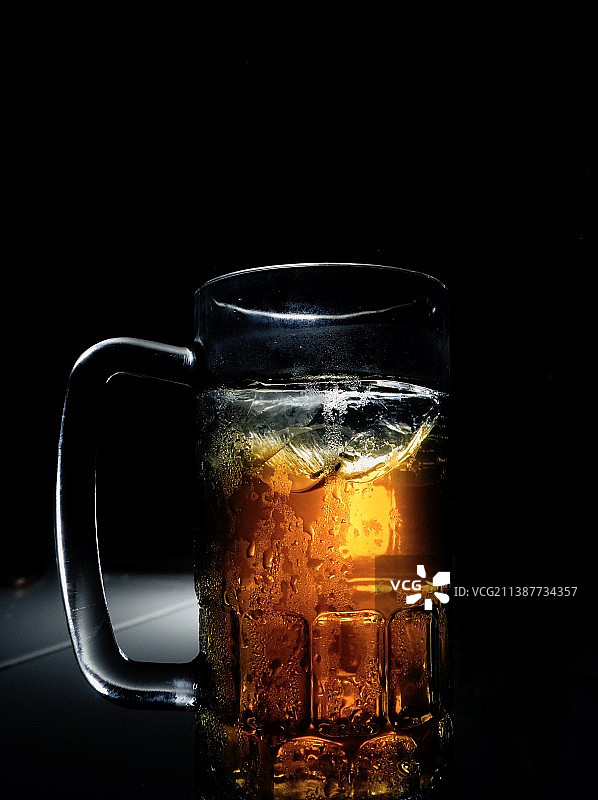 特写的啤酒杯在桌子上的黑色背景图片素材