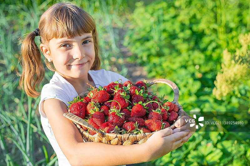 一个手里拿着草莓的孩子选择性聚焦图片素材