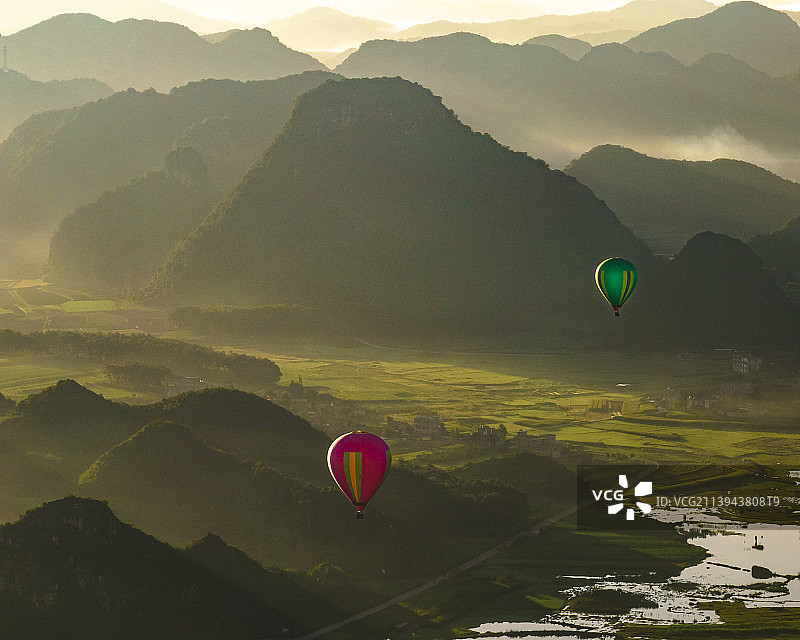 热气球穿梭丘陵图片素材