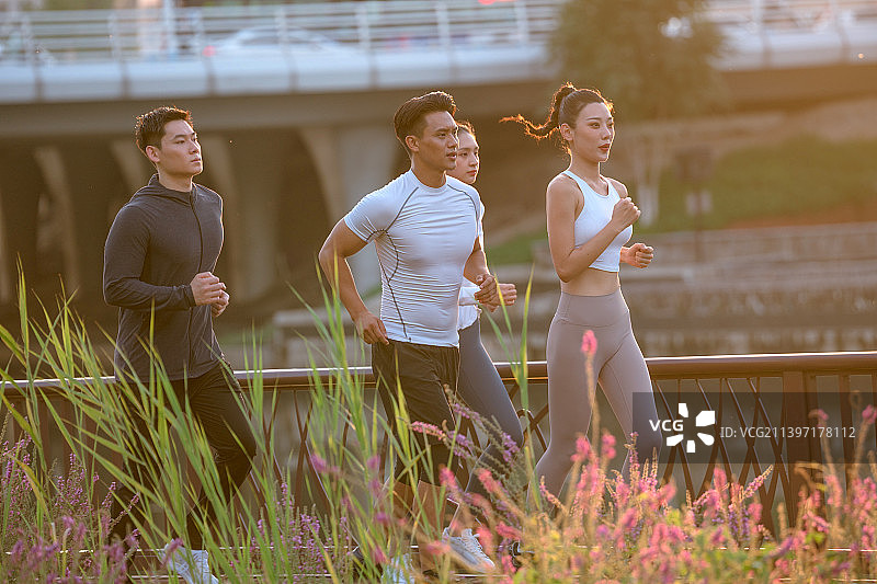 四个年轻人在城市公园里跑步图片素材