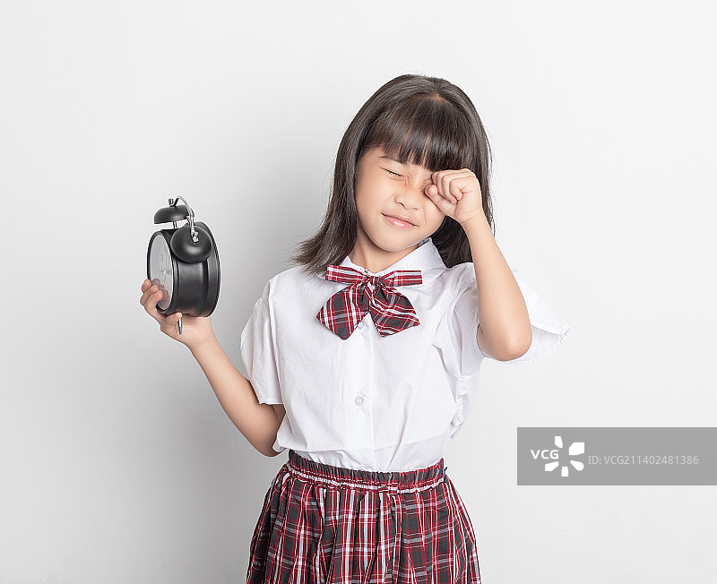 一个中国小学生小女孩手拿着一个闹钟图片素材