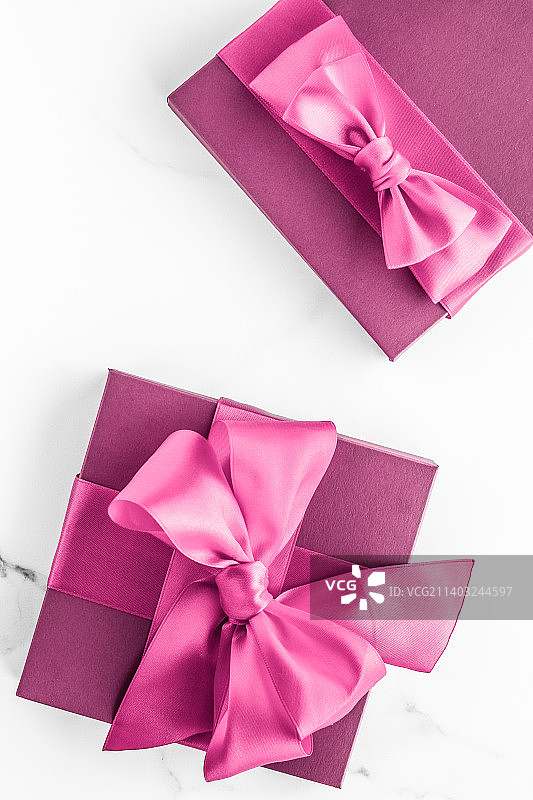 粉红色礼品盒与丝绸蝴蝶结在大理石背景，女孩婴儿淋浴图片素材