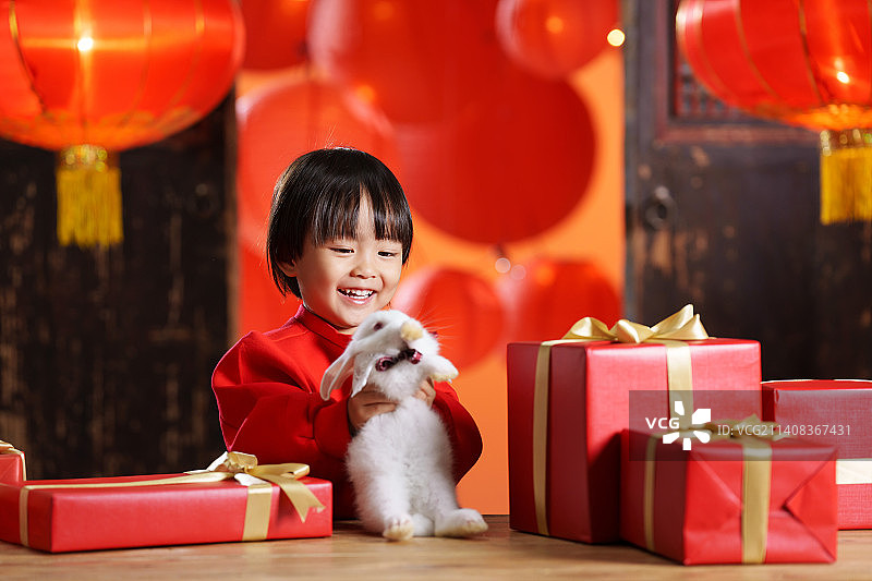 可爱的小男孩收到新年礼物小兔子图片素材