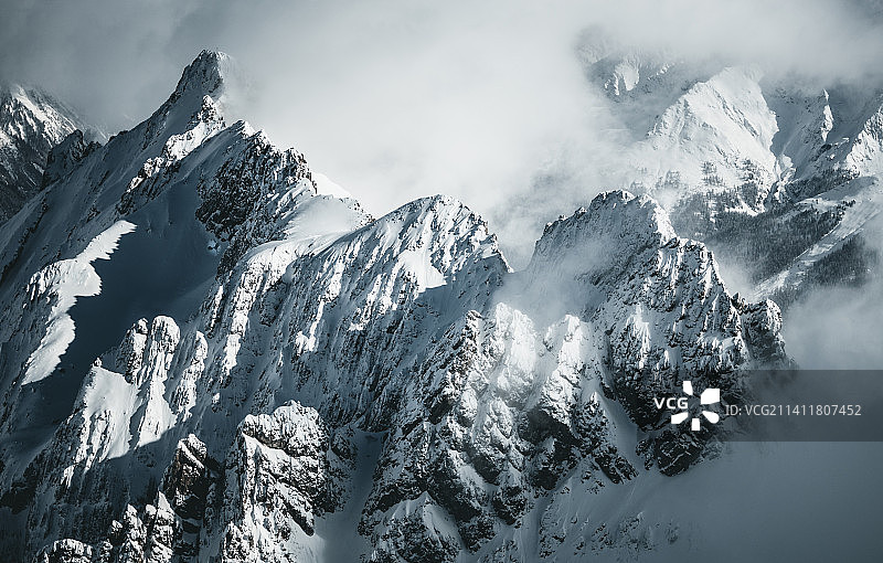 在奥地利的阿尔伯格地区，被雪覆盖的山脉在云层之上图片素材